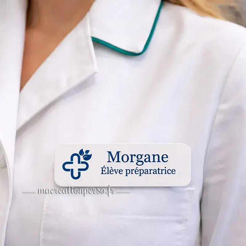 Badge préparatrice en pharmacie personnalisé avec prénom porté sur blouse, usage en officine