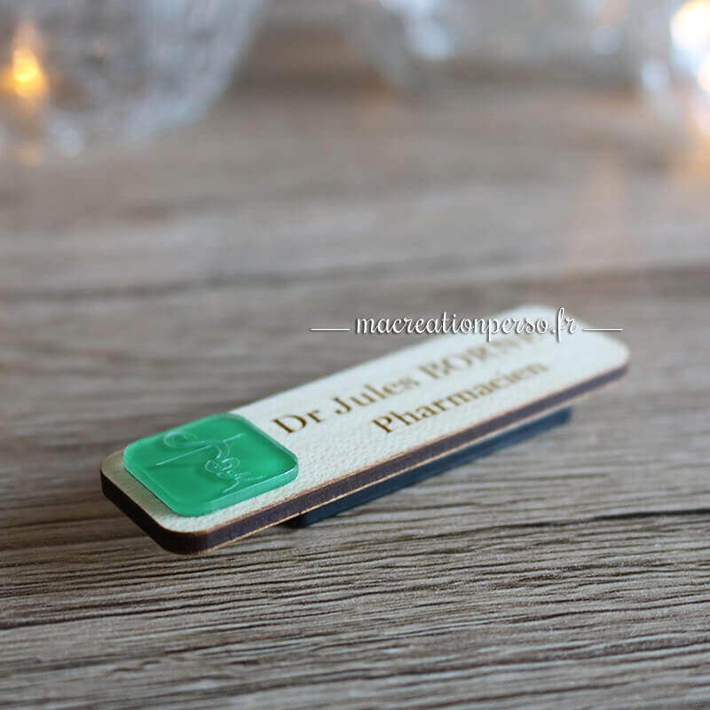 Badge en bois avec coupe d'hygie gravée sur une matière verte transparente