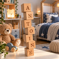 Cubes lettres en bois massif empilés formant le prénom Antoine dans une chambre d'enfant
