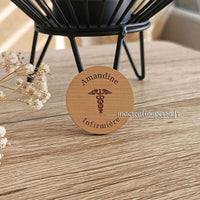 Face avant du badge rond infirmière en bois avec caducée